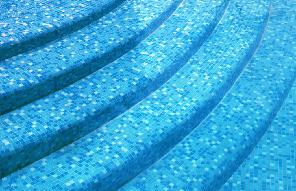 curved-steps-swimming-pool-with-blue-tile-mosaic